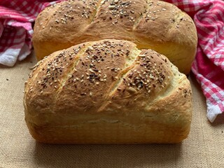 Baked homemade bread with flax seeds. Whole grain pastry in assortment lies on the table.