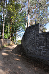 Fototapeta premium Road along a brick fence in Kodaikanal, Tamil Nadu, India