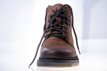 Men's winter boot made of genuine leather and natural fur on a light background.