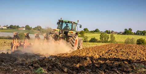 Tracteur dans la campagne en train de labourer la terre.
