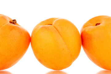 Three ripe sweet apricots, close-up, isolated on a white background.