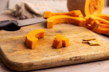 Cutting pieces of pumpkin on a chopping board