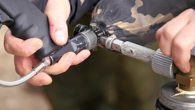 Paintball. Filling the marker with gas, pumping air into an air gun.