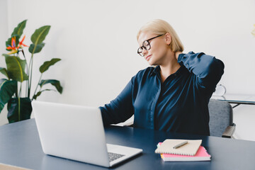 Young caucasian tired sad businesswoman suffering from neck pain, stretching rubbing her neck nerve...