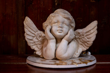 white angel with gold on a wooden background