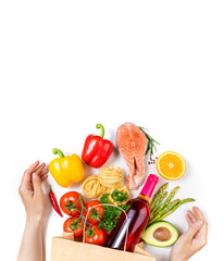 Healthy food background. Womans hands and healthy foods in paper bag fish, vegetables and fruits on white. Shopping food supermarket concept. Copy space