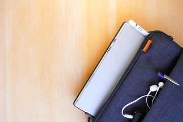 Blue laptop case with stylus pen on wooden table 