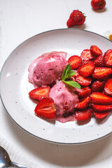 Homemade strawberry ice cream decorated with fresh berries and mint