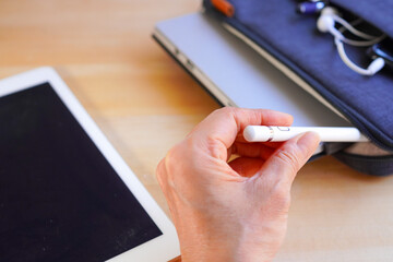 Woman taking stylus pen out of the laptop case 