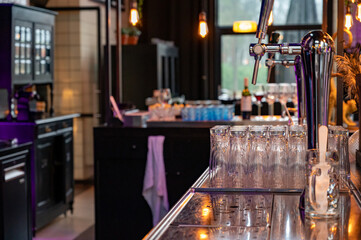 Interior of classic bar with beer taps and empty glasses in cafe