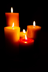 Burning red candles on black background