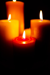 Burning red candles on black background