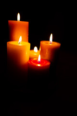 Burning red candles on black background