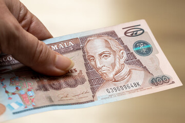 Female hand holding 100 Guatemalan quetzal banknote