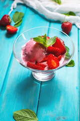 Homemade strawberry ice cream decorated with fresh berries and mint