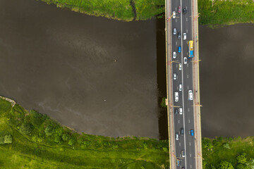 aerial view on heavy traffic on a bridge with a wide multi-lane road across a wide river
