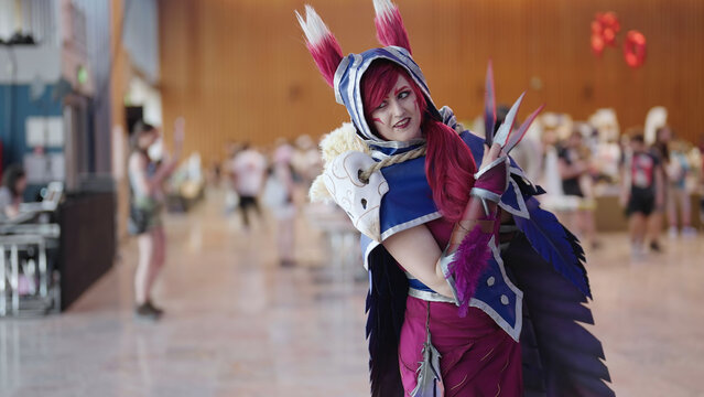 Comic con cosplay character Xayah from League of Legends game pose