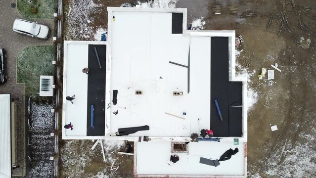 Roofing construction worker installing a flat roof.