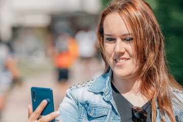 girl on the street with mobile phone recording or making selfie