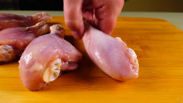Fresh chicken legs on a cutting board.