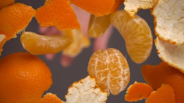 Falling mandarin slices on a background of tangerine