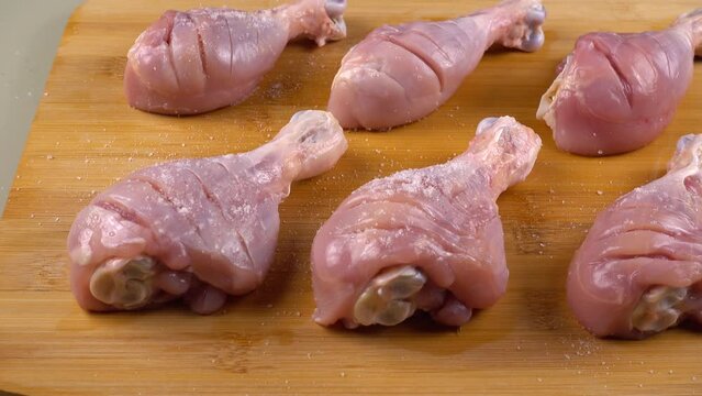 The process of pickling chicken legs on a cutting board.