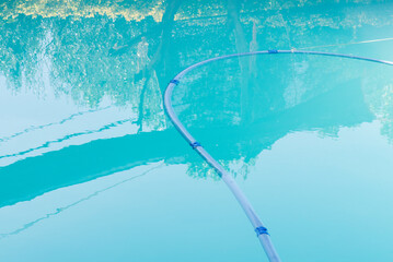 Reflejo agua azul de piscina con robot de limpieza flotando