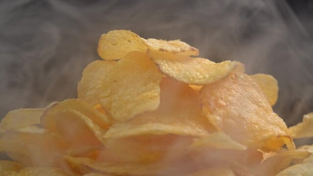 Craft crispy hot potato chips with smoke rotating on