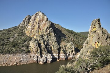Forbidding cliffs at the confluence gorge of Tajo and Tietar rivers, encrusted in salt, rising from...