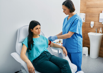 Nurse taking blood for allergen testing by collecting blood in test tubes at laboratory