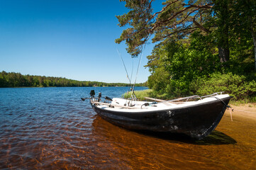 Naklejka na ściany i meble Small fishing motorboat in summer lake scenery