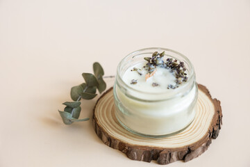 Handmade candle from paraffin and soy wax in glass with wooden wick and dry herbal isolated on...