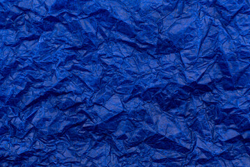 Texture of crumpled paper in blue. Background from old dark paper