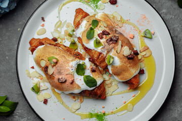 croissant with sweet cream and almonds on a plate. Delicious and healthy breakfast