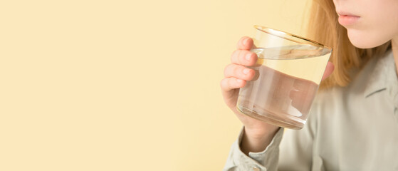 Woman drinking fresh water on color background with space for text, closeup