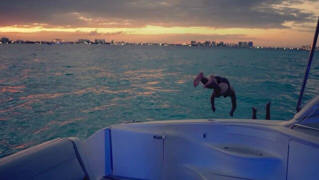 Grupo de j&oacute;venes ech&aacute;ndose un clavado al mar desde un yate