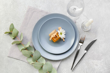 Table setting with honey bonbonniere on light background