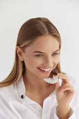 Teeth Whitening. Woman with White Smile, Using Removable Braces. Girl Using Teeth Whitening Tray, Holding Invisible Braces. Dental Treatment Concept. High Resolution Image