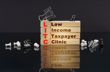 On a black reflective surface, wooden blocks with the inscription - Low Income Taxpayer Clinic