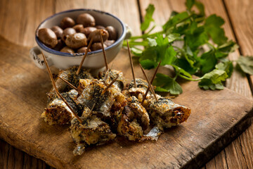 oven stuffed sardines with black olives and parsley over cutting board