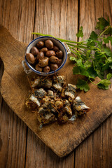 oven stuffed sardines with black olives and parsley over cutting board