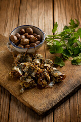 oven stuffed sardines with black olives and parsley over cutting board