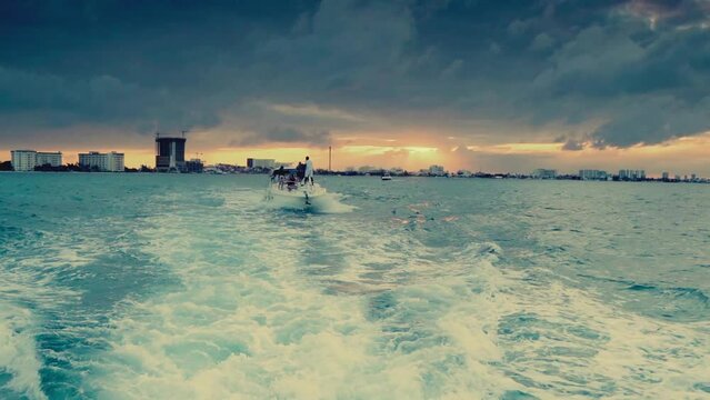 j&oacute;venes divirtiendose en un yate en el atardecer