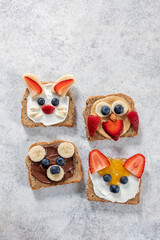 Funny animal faces toasts with spreads, butters, banana, strawberry and blueberry. Look like bunny,...