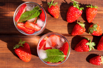 Two glasses of fresh strawberry lemonade with ice and mint on the table. Summer refreshment drinks. Top view