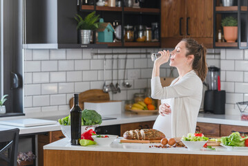 Young pregnant woman drinking water. A healthy diet during pregnancy