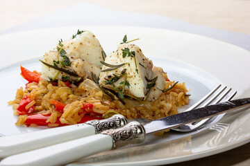 Fish dish - fried cod fillet with boiled white rice and fresh fruit salsa on white table