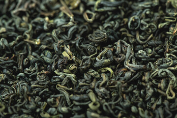 Chinese green leaf tea. Dried tea leaves background, top view
