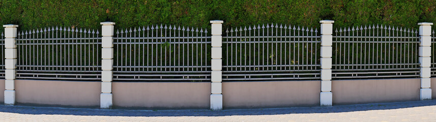 Panorama of a double fence. Metal and live fences.