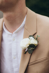 elegant boutonniere in the lapel buttonhole of the groom's suit